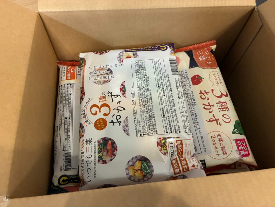 『ワタミの宅食ダイレクト』の段ボールを開封した様子。コンパクトな冷凍弁当（いつでも三菜）が10パックがぎっしりと収納されている。